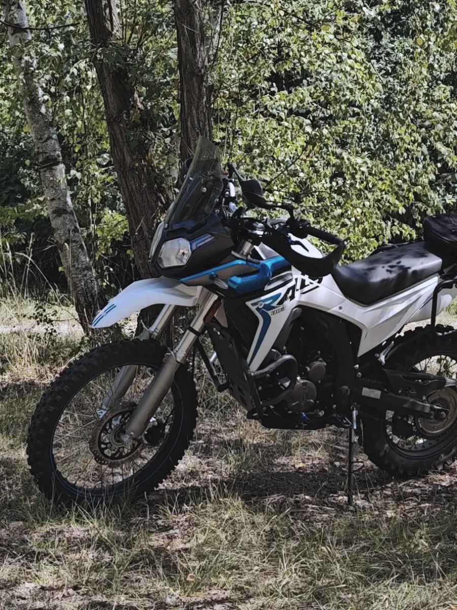 Voge 300 Rally v bílo-modré na lesní cestě